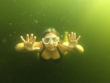 Photo of Anna Swanson in goggles swimming underwater 